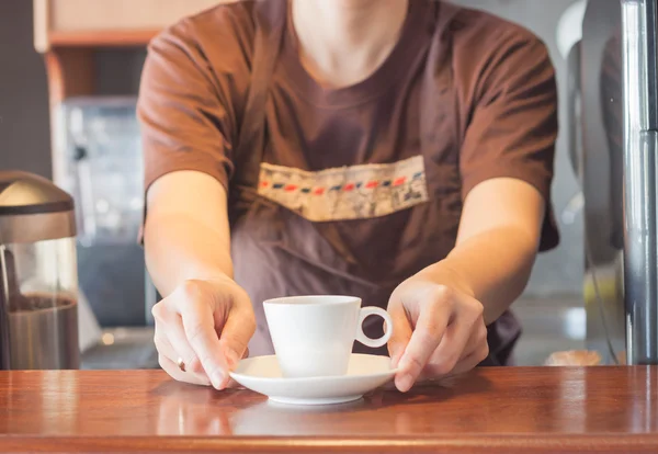 Barista offering mini white cup of coffee — Stock Photo, Image