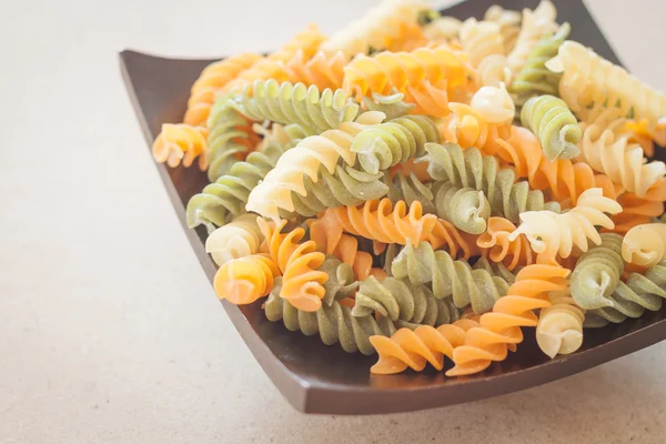 Pasta fusilli cruda su vassoio di legno — Foto Stock