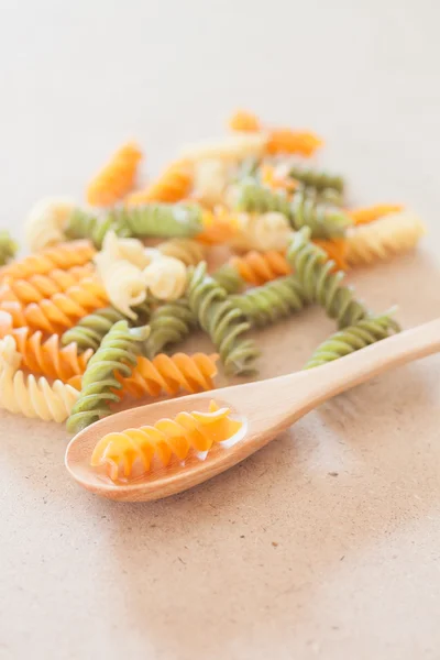 Pasta de fusilli cruda con cuchara de madera — Foto de Stock