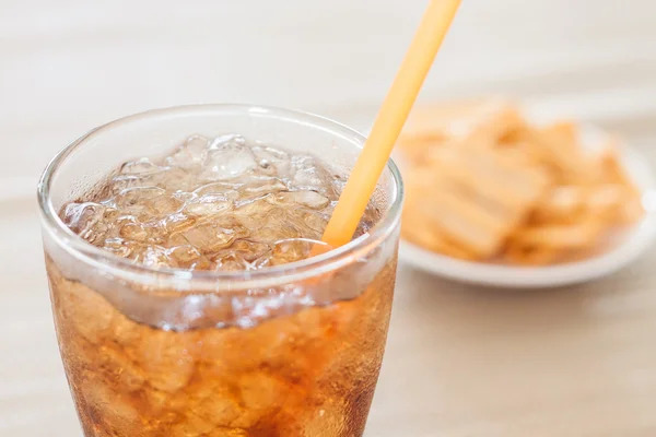 Een glas cola met snack op wit bord — Stockfoto