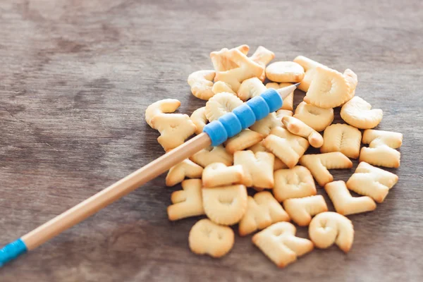 Alphabet biscuit on wooden table — Stock Photo, Image