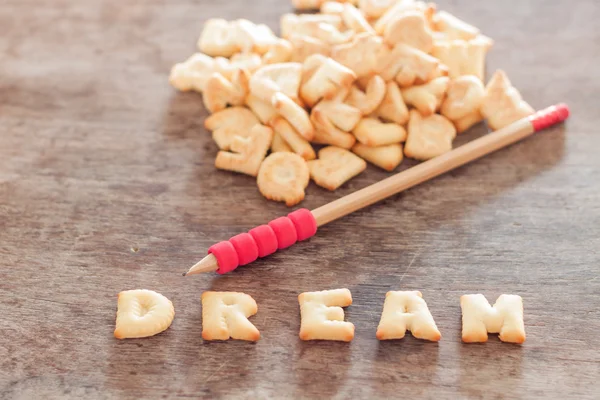 Biscoito de alfabeto de sonho na mesa de madeira — Fotografia de Stock