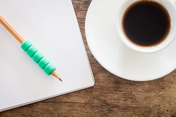 Lápiz en cuaderno en blanco abierto con taza de café — Foto de Stock