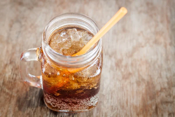 Vaso de cola con hielo sobre mesa de madera —  Fotos de Stock