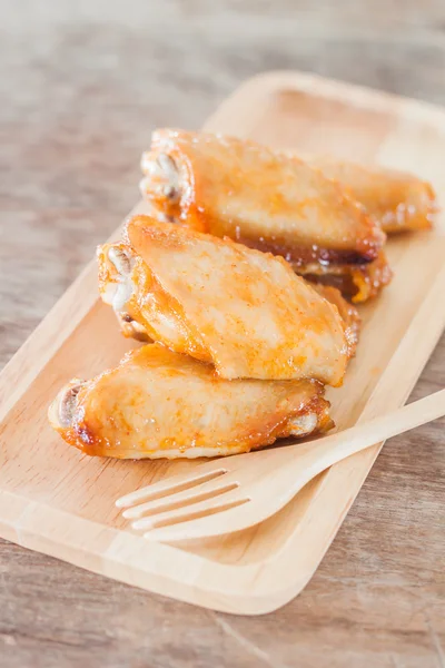 Grilled chicken wings on wooden plate — Stock Photo, Image