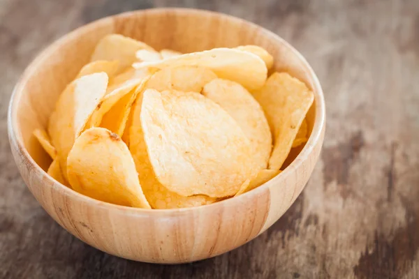 Crispy potato chips on wooden background — Stock Photo, Image