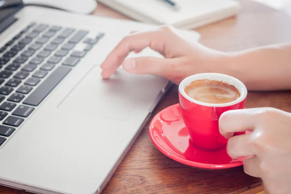 Red coffee cup with notepad and laptop — Stock Photo, Image