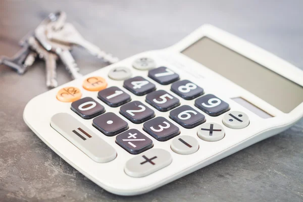 Kalkulator z kluczami na szarym tle — Zdjęcie stockowe