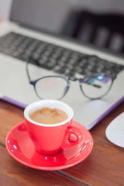 Röd kaffekopp på arbetsplats — Stockfoto