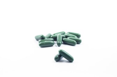 Green capsule pills on white background