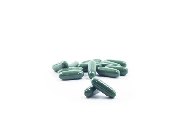 Green capsule pills on white background — Stock Photo, Image