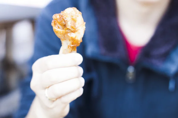 Hand holding grilled chicken wing — Stock Photo, Image