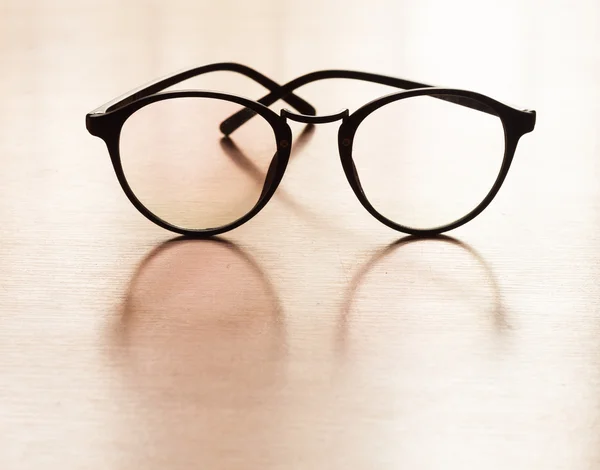 Óculos com reflexão sobre mesa de madeira — Fotografia de Stock