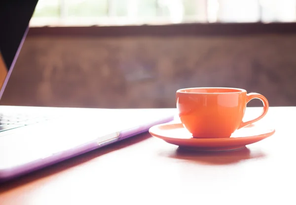Xícara de café com teclado na mesa de madeira — Fotografia de Stock