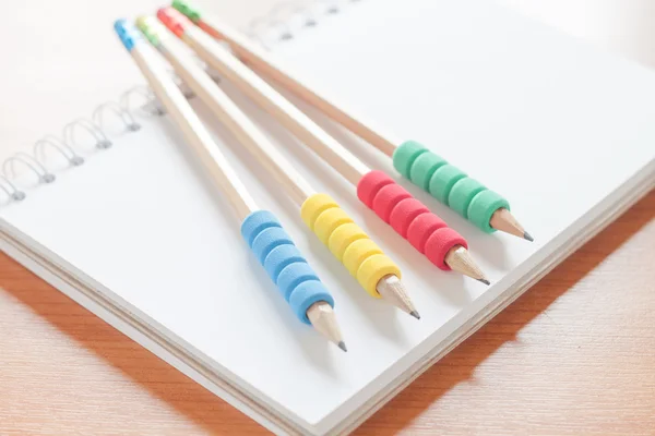 Pencils on open blank white notebook on the desk — Stock Photo, Image