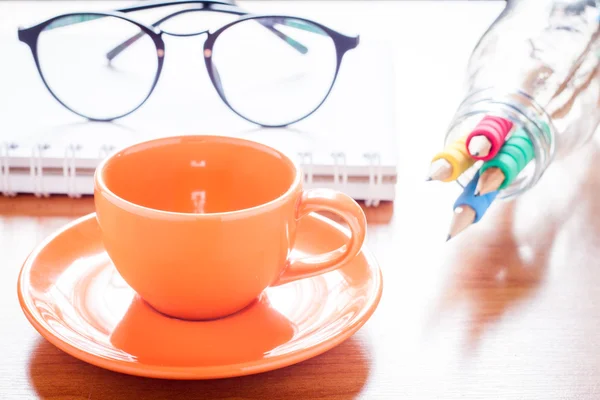 Närbild på kaffekoppen med bok och glasögon — Stockfoto