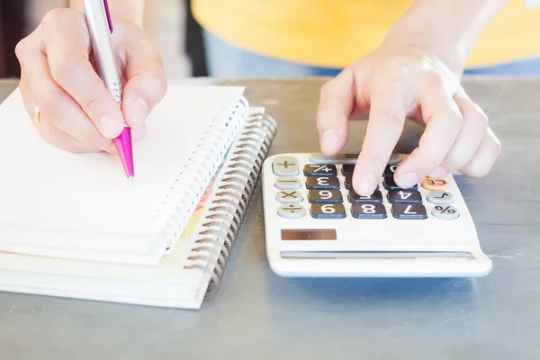 Mão segurando caneta e pressionando botões calculadora — Fotografia de Stock