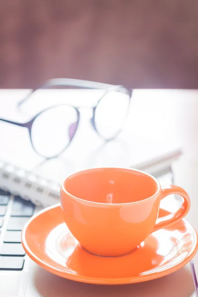 Portátil con taza de café y bloc de notas en el escritorio — Foto de Stock