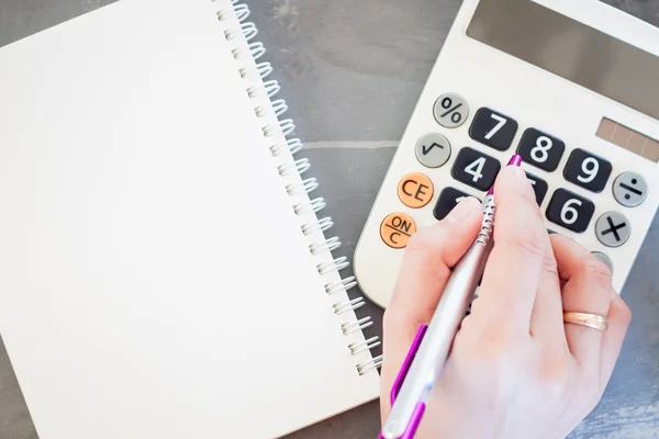 Hand mit Taschenrechner und Notizblock — Stockfoto