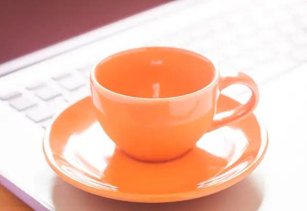 Primo piano tazza di caffè sul computer portatile — Foto Stock