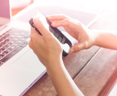 Akıllı telefon ve dizüstü bilgisayar kullanan kadın