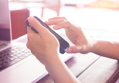 Akıllı telefon ve dizüstü bilgisayar kullanan kadın