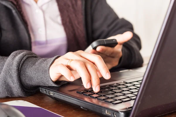 Woman using smart phone at office desk — Stock Photo, Image