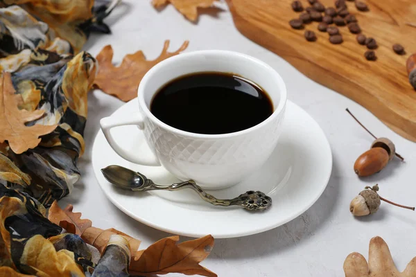 Acorn coffee with fall oak leaves on gray background. Coffee substitute without caffeine. Closeup.
