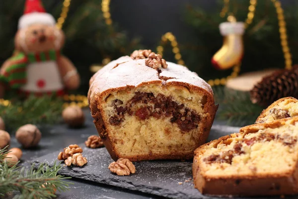 Christmas cupcake with nuts, covered with icing sugar on the Christmas background. Closeup. Horizontal format — Stock Photo, Image