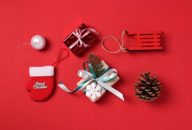 Kırmızı arka planda Noel hediyeleri ve dekorun Noel kompozisyonu. Boks günü. Tebrik kartı. - Mutlu yıllar. Düz yatıyordu. Üst görünüm.