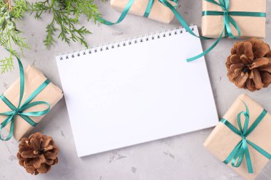 Gri yüzeyi yeşil kurdeleli Noel hediyesi kutuları. Dilekler için yer. Tatil kartı. Yukarıdan görüntüle