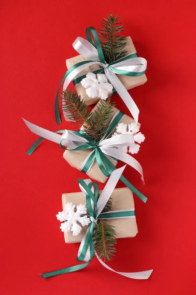 三个圣诞礼品盒 红色表面有绿色和白色的缎带 度假卡顶部视图 纵向格式 — 图库照片