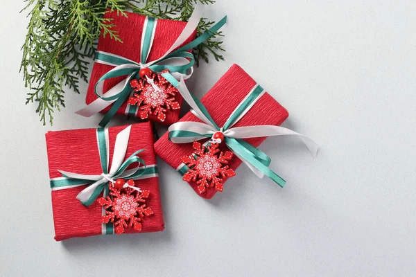 三件圣诞礼物 红色的纸 上面铺着雪花和彩带 圣诞节礼物 平躺在床上假日卡片 — 图库照片