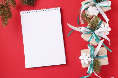 Kırmızı yüzeyinde yeşil ve beyaz kurdeleler olan Noel hediyesi kutuları. Dilekler için yer. Tatil kartı. Üst görünüm.