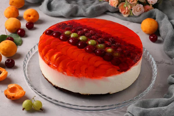 Красный желейный торт с ягодами и сметаной на сером фоне. Крупный план. Горизонтальный формат — стоковое фото
