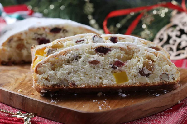 Christmas tasty stollen with dry fruits, berries and nuts on wooden board. Traditional German treats. — Stock Photo, Image