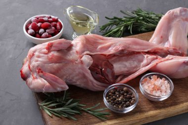 Taze çiğ tavşan zeytinyağı, biberiye, biber, deniz tuzu ve Cornelian kirazları ile ahşap zemin üzerinde