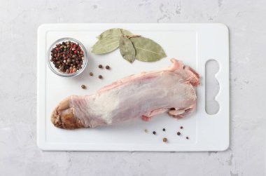 Çiğ domuz dili, biber karışımı ve plastik beyaz bir tahta üzerinde defne yaprağı. Yukarıdan görüntüle.