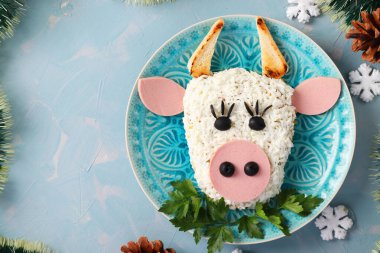 2021 yılı için açık mavi arka planda boğa şeklinde şenlikli salata, yeni yıl için sembolik yiyecek, Top view. Boşluğu kopyala