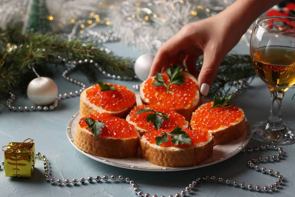 Sandvișuri Caviar Roșu Farfurie Fundal Albastru Deschis Femeia Ajunge Sandvişul — Fotografie, imagine de stoc