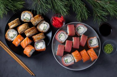 Somon, ton balığı ve Philadelphia peynirli yılan balığı soslu Noel yemeği. Yeni yıl partisi. Koyu arkaplanda üst görünüm