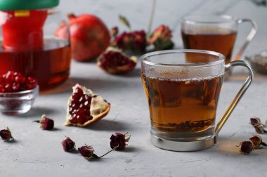 Limonlu ve tarçınlı nar çayı iki şeffaf fincanda gri arka planda. Sıcaklık içeceği.
