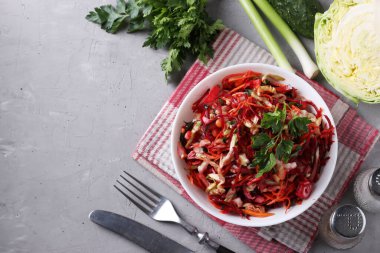 Taze sebzelerden salata: lahana, pancar, havuç, salatalık, soğan ve gri arka planda maydanoz. Yukarıdan bak. Metin için boşluk