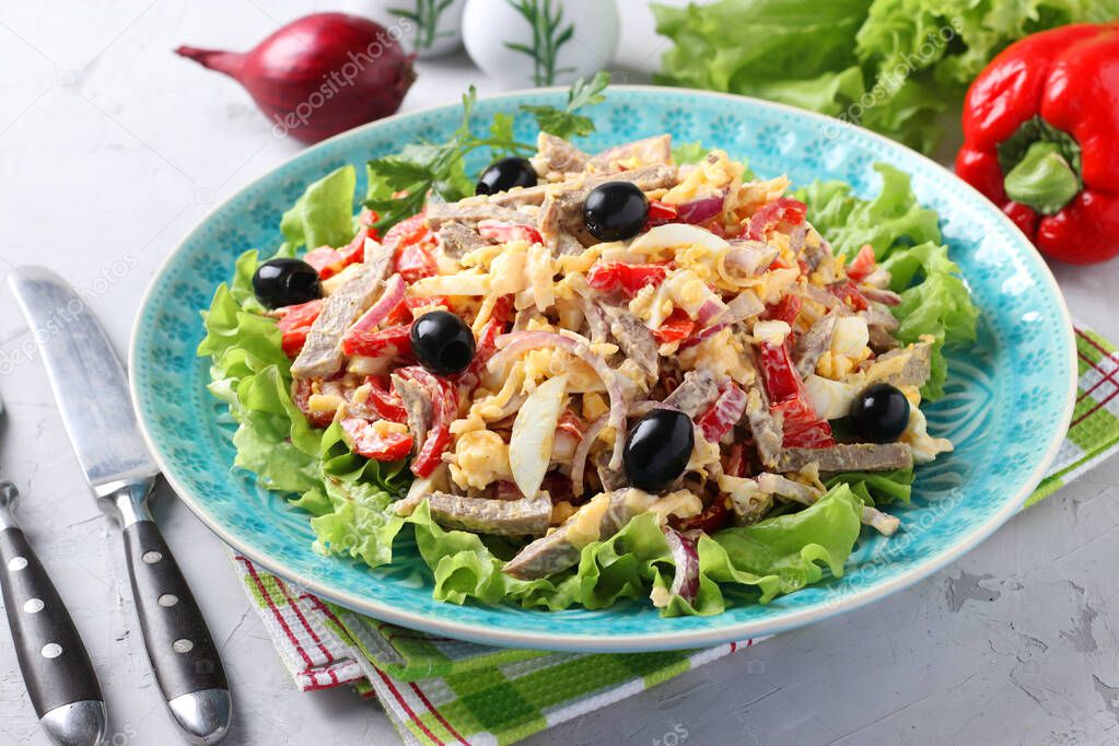 Salad with tongue, bell peppers, eggs, lettuce, cheese and black olives on blue plate on grey background. Close-up