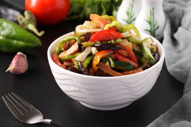 Beyaz kasede patlıcanlı, domatesli, biberli ve salatalıklı salata. Yakın çekim..