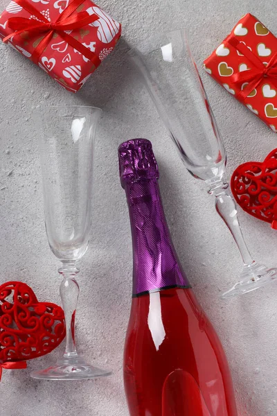 Sticlă de șampanie de trandafir, două pahare și cadouri pe fundal gri. Conceptul de Valentine Day. Vedere de sus . — Fotografie, imagine de stoc