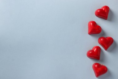 Açık mavi arka planda kalp şeklinde çikolatalar. Yukarıdan bak. Metin için boşluk