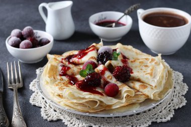 İnce krep, buğday unu, yumurta ve kefir, böğürtlen, reçel ve kahve ile servis edilir. Yakın çekim.