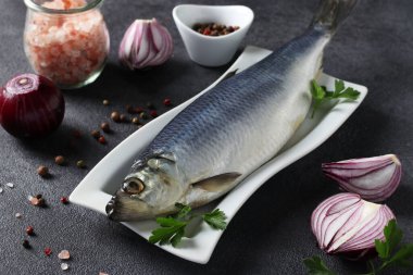 Kırmızı soğanlı tuzlanmış ringa balığı, biber, deniz tuzu ve gri arka planda maydanoz. Kapat.