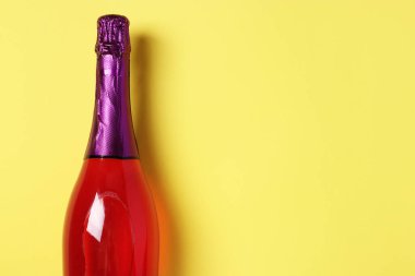 Sarı arka planda parıltılı pembe şampanya. Metin için boşluk.